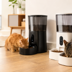 Dos gatos comiendo pienso en comederos automáticos dentro de una vivienda luminosa